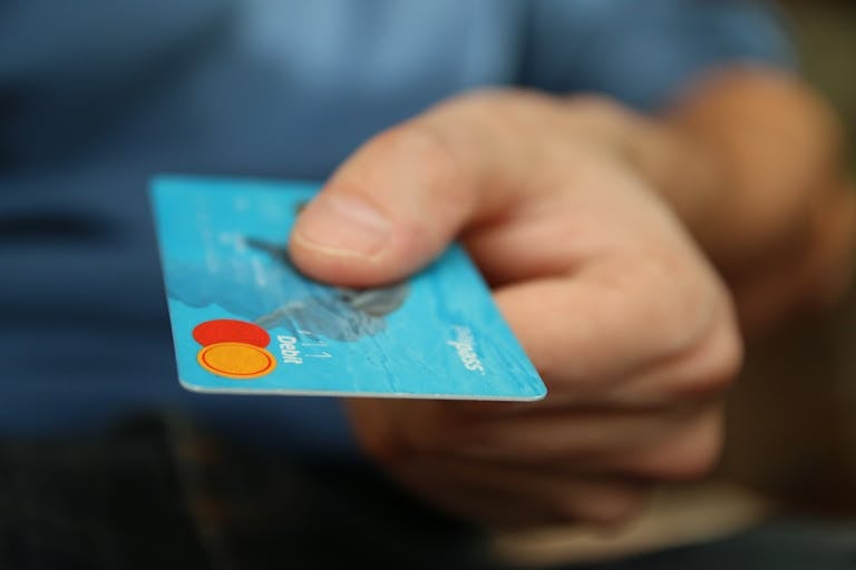 main qui tend une carte de paiement
